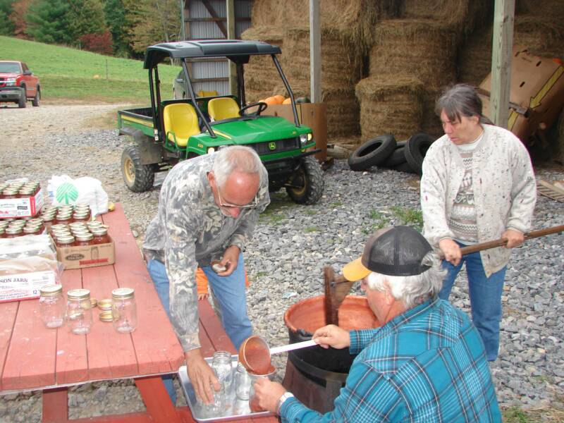 Ronald, Jennifer's Mom, and Dad putting apple butter in jars